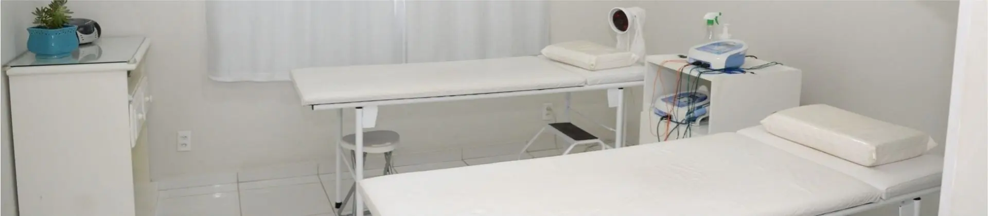 Sala de fisioterapia com duas macas e aparelhos